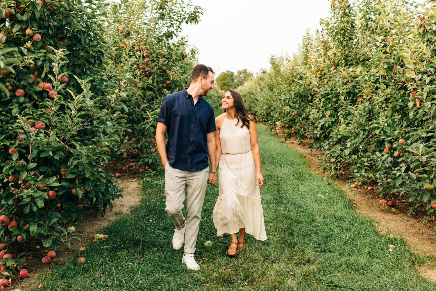 couple-walking-in-apple-orchard